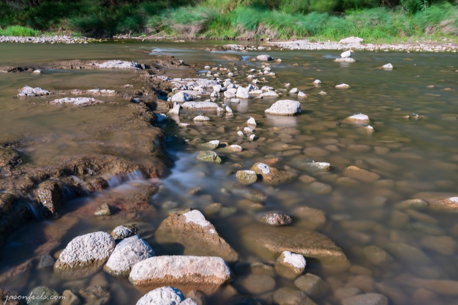Long exposure of water rushing over rocks in the Colorado river Texas
