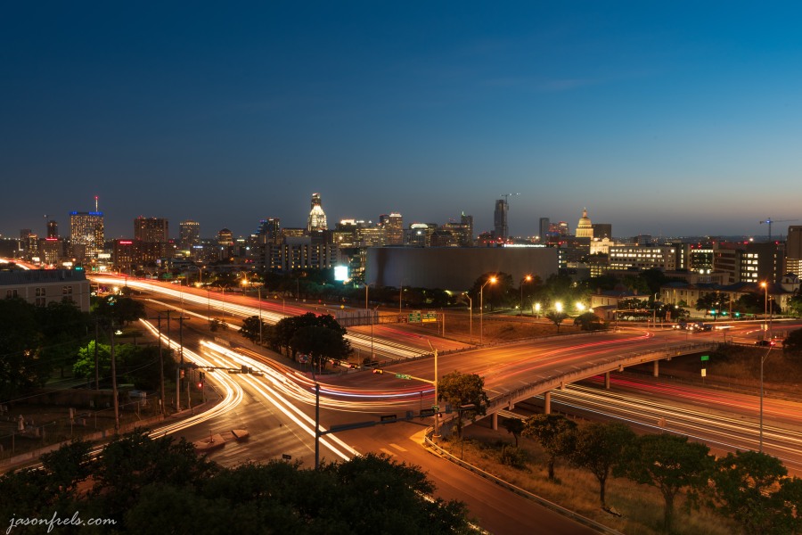 Austin Texas skyline at night with car light trails on IH35