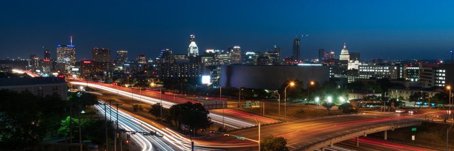 Austin Texas skyline at night with car light trails on IH35