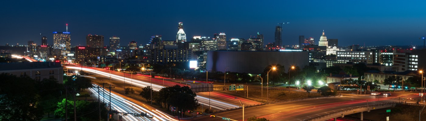 Austin Texas skyline at night with car light trails on IH35