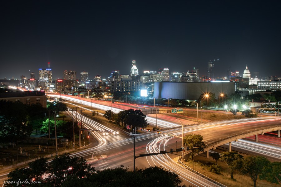 Austin Texas skyline at night with car light trails on IH35