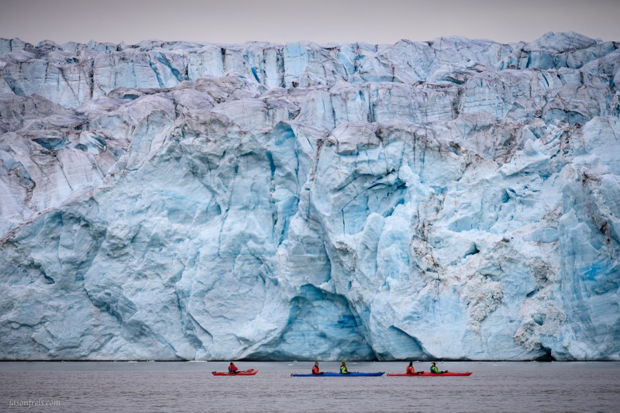 Kayaks in front of a glacier